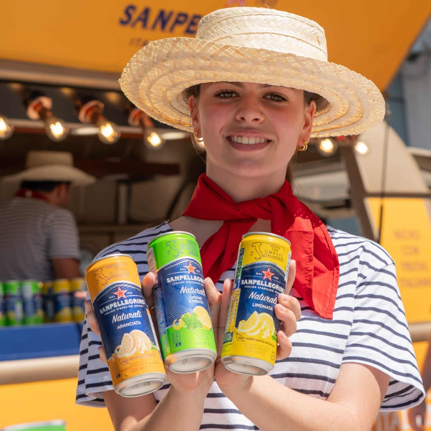Azafata de grupoSky sosteniendo latas de San Pellegrino